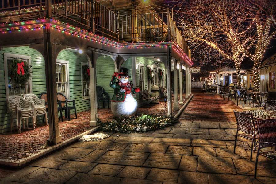 Picture of aHoliday scene with a snowman on a front porch