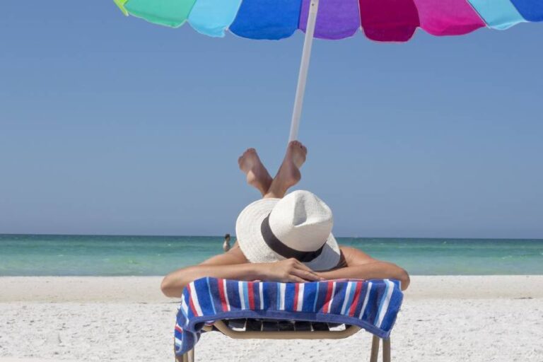 picture of a person on the sandy beach with an umbrella for shade