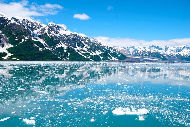 picture of water in Alaska with scattered ice and mountains in the background
